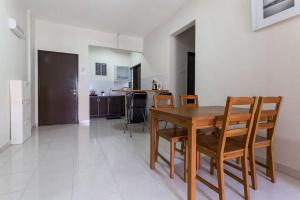 a kitchen and dining room with a wooden table and chairs at Ratu Musleem Homestay in Kuala Selangor