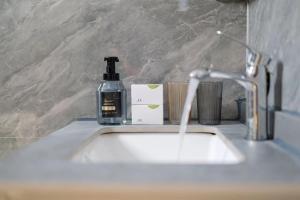 un lavandino in bagno con una bottiglia di sapone di Dali Linghaoyun Homestay a Dali Altre 25 foto