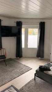 een woonkamer met een flatscreen-tv aan de muur bij Fewo Monteurwohnung SAW in Salzwedel +4 foto's