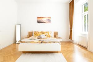 a bedroom with a bed in a white room at Stilvolles Altbau Apartment - 2 Min zur U-Bahn, Nähe Donaukanal in Vienna