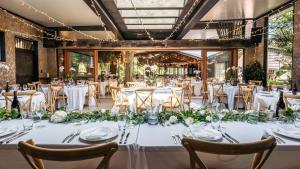 a table set up for a wedding with white tables and flowers at Kauri Springs Lodge still the same beautiful place but so so much better in Waiheke Island