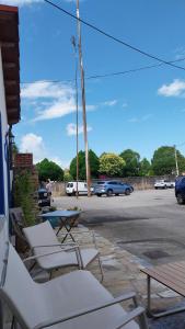 a group of chairs and a table and a parking lot at La Mar de Nueva AT in Nueva de Llanes
