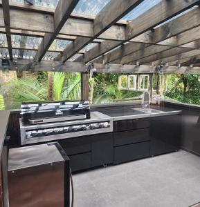 a kitchen with a stove and a sink at Kauri Springs Lodge still the same beautiful place but so so much better in Waiheke Island