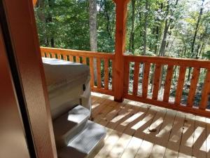 - une terrasse couverte avec un lit et une grande fenêtre dans l'établissement Cozy Family-Friendly Cabin with Private Outdoor Jacuzzi near Huntington, West Virginia, à Genoa