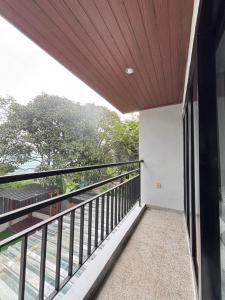 a balcony of a house with a wooden ceiling at Villa Andira Hidden Paseban in Pondok Cipaseban