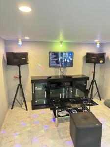a living room with two speakers and a tv on a wall at Villa Andira Hidden Paseban in Pondok Cipaseban