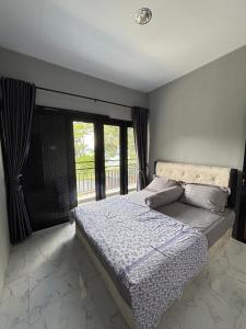 a bedroom with a bed and a large window at Villa Andira Hidden Paseban in Pondok Cipaseban +3 photos