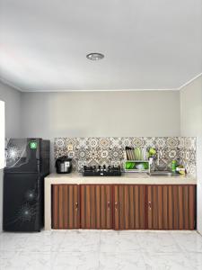a kitchen with a stove and a refrigerator at Villa Andira Hidden Paseban in Pondok Cipaseban