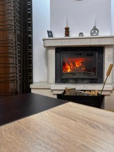 a fireplace with a table in front of it at Pamporovo Duplex Apartment Fireplace 2 Bathrooms Shuttle in Smolyan