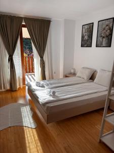 a bedroom with a large bed in front of a window at Pamporovo Duplex Apartment Fireplace 2 Bathrooms Shuttle in Smolyan