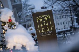 een bord voor een gebouw met een kerstboom bij Villa Rein Boutiquehotel in Bad Reichenhall