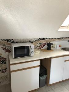 a microwave sitting on a counter in a kitchen at PäRLAN APARTMAN in Balatonboglár +11 photos