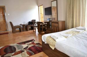 a hotel room with a bed and a dining room at Hotel GaiaYuel in Thimphu