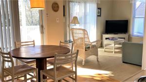 Cape May PointにあるSomewhere In Time Unit 4のテーブルと椅子とテレビのあるリビングルーム