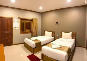 a hotel room with two beds and a door at Champadiamon hotel in Pakse