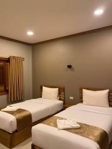 a bedroom with two beds with white pillows at Champadiamon hotel in Pakse