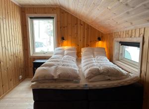 a large bed in a room with wooden walls at Cozy family cabin at Hovden in Bykle
