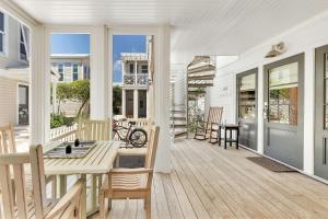 a white porch with a bench and a table at On the Beach in Santa Rosa Beach