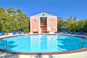 a large swimming pool with blue chairs and a building at On the Beach in Santa Rosa Beach