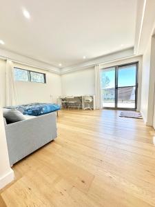een grote woonkamer met een bed en een hardhouten vloer bij Master room with Ensuite Near Train Station Airport in Revesby
