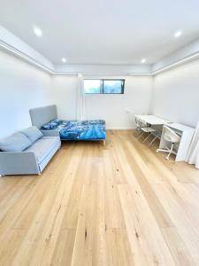een woonkamer met een bank en een tafel bij Master room with Ensuite Near Train Station Airport in Revesby +5 foto's