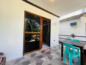 a dining room with a table and blue chairs at Kiera Homestay in General Luna