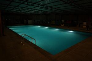 a large swimming pool with lights in a building at Turiya Retreat in Auroville