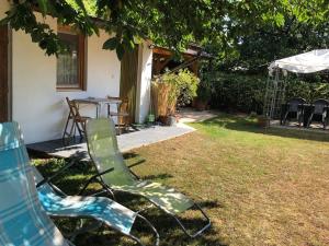 two lawn chairs and a table in a yard at PäRLAN APARTMAN in Balatonboglár