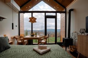 a bedroom with a bed and a table and a large window at Brvnara Vila Promaja in Kladovo +85 photos