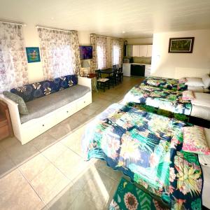 a bedroom with two beds and a couch at Rooi Bij de Knoptoren B&B in Sint-Oedenrode