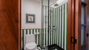 a bathroom with a toilet and green and white stripes at Sugar Marina Resort-LAGOON-Villas, Naiyang Beach in Nai Yang Beach