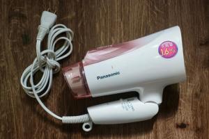 a white hair dryer sitting on a wooden table at 夏様四条大宮 四条大宮駅5分 京都市中心部 一棟一組貸切 広い庭付き一戸建て in Kyoto