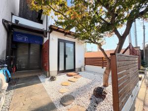 a building with a tree in front of it at 夏様四条大宮 四条大宮駅5分 京都市中心部 一棟一組貸切 広い庭付き一戸建て in Kyoto