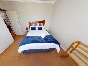 a bedroom with a bed with blue and white sheets at Bay view sea cottage in Victoria Bay +4 photos