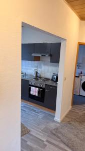 a kitchen with black counters and a stove top oven at Fewo Monteurwohnung SAW II in Salzwedel +4 photos