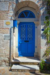 a blue door in a stone building with a stone wall at MINIQ HOMES 103 - Stone House with Garden Cinema, Barbecue, Mini Golf in Foca