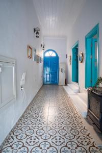 a hallway with a blue door and a tile floor at MINIQ HOMES 103 - Stone House with Garden Cinema, Barbecue, Mini Golf in Foca