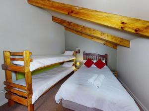 two twin beds in a room with wooden ceilings at Bay view sea cottage in Victoria Bay