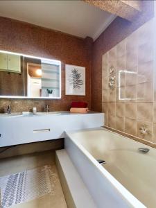 a bathroom with a tub and a sink and a mirror at Charmant dupleix à La Baule, proche de la mer in La Baule