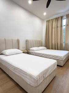 two beds sitting next to each other in a bedroom at relaxing home in Bukit Mertajam in Bukit Mertajam