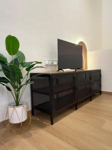 a black desk with a tv on top of it at relaxing home in Bukit Mertajam in Bukit Mertajam