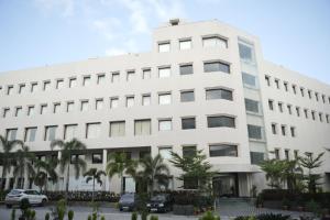 un bâtiment blanc avec des palmiers devant dans l'établissement Avasa Homestay, à Thūr