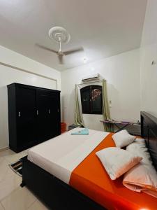 - une chambre avec un lit orange et blanc dans l'établissement Luxor Adventure Guest House, à Al Aqālitah