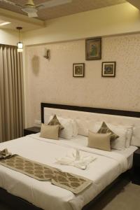 une chambre avec un grand lit avec des draps blancs dans l'établissement Avasa Homestay, à Thūr