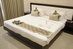 une chambre avec un grand lit avec des draps blancs dans l'établissement Avasa Homestay, à Thūr