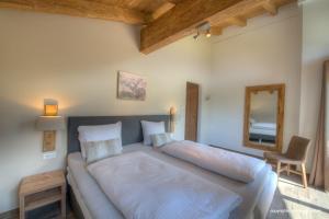 um quarto com uma cama grande e um espelho em Deer & Dear Luxury Chalet em Piesendorf