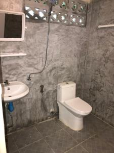 a bathroom with a toilet and a sink at Baan Suan Coconut Ko Yao Noi in Ko Yao Noi