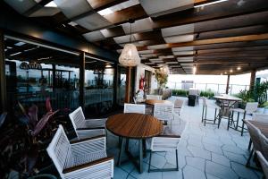 eine Terrasse mit einem Holztisch und Stühlen auf einer Terrasse in der Unterkunft Experiência a beira mar, Jacuzzi e conforto in Água Boa