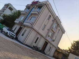 a building with a car parked in front of it at Hotel O RG PALACE HOTEL in Bagru