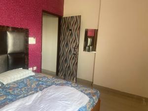 a bedroom with a bed and a door in a room at Hotel O RG PALACE HOTEL in Bagru